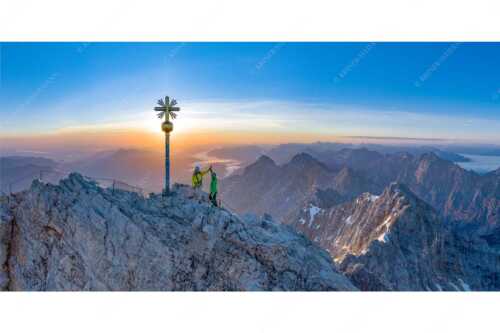 Gipfelerfolg auf der Zugspitze mit Blick über Jubiläumsgrat und Alpspitze in den Sonnenaufgang - high five - Seitenverhältnis 2:1 - Bergsteiger auf der Zugspitze - weitere Infos unter https://www.kriner-weiermann.de