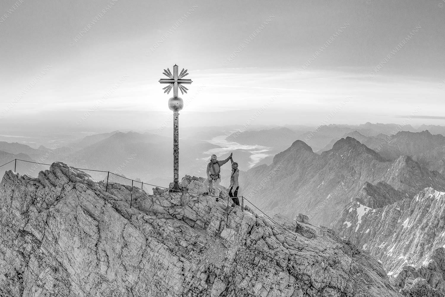 high five – Seitenverhältnis 3:2 — Bergsteiger auf der Zugspitze Gipfelerfolg auf der Zugspitze mit Blick über Jubiläumsgrat und Alpspitze in den Sonnenaufgang