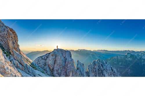 Blick von der Oberen Wettersteinspitze in den Sonnenaufgang - Oberer Wetterstein - Seitenverhältnis 2,5:1 - Bergsteiger am Wettersteingipfel - weitere Infos unter https://www.kriner-weiermann.de