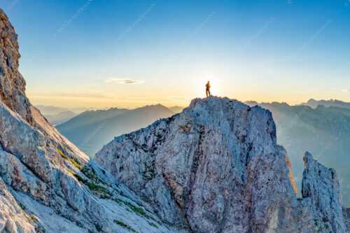 Blick von der Oberen Wettersteinspitze in den Sonnenaufgang - Oberer Wetterstein - Seitenverhältnis 3:2 - Bergsteiger am Wettersteingipfel - weitere Infos unter https://www.kriner-weiermann.de