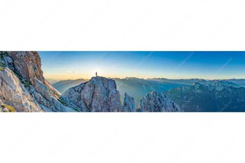 Blick von der Oberen Wettersteinspitze in den Sonnenaufgang - Oberer Wetterstein - Seitenverhältnis 4:1 - Bergsteiger am Wettersteingipfel - weitere Infos unter https://www.kriner-weiermann.de