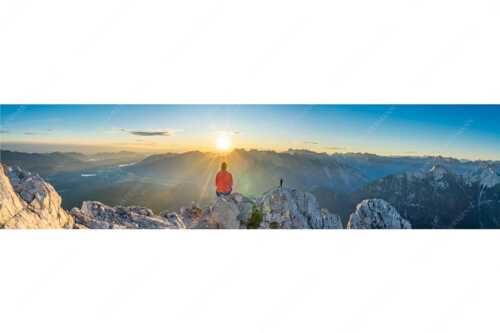 Blick übers Obere Isartal in den Sonnenaufgang im Karwendel - Sonnenanbeter - Seitenverhältnis 4:1 - Bergsteiger auf der Wettersteinspitze - weitere Infos unter https://www.kriner-weiermann.de