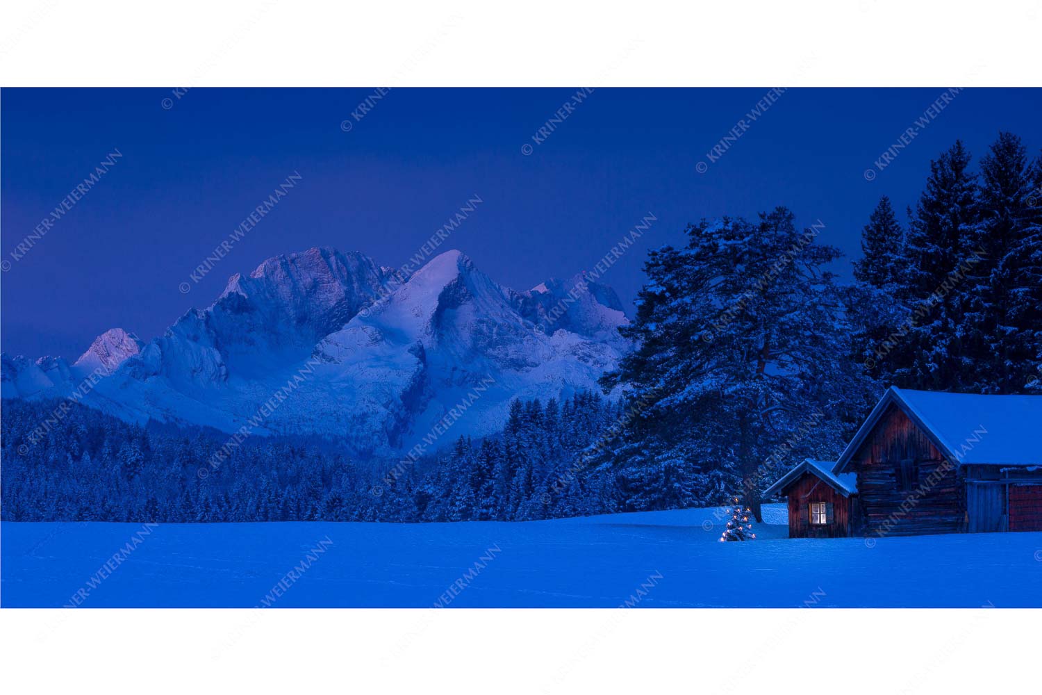 Weihnachtliches Wiesmahdhütterl mit dem ersten Licht an der Alpspitze Und Zugspitze