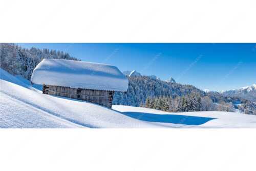 Wiesmahdstadel mit Stanker und viel Schnee mit Alpspitze, Zugspitze und Waxenstein im Hintergrund - Winter satt - Seitenverhältnis 3:1 - viel Schnee Stadel mit Zugspitze - weitere Infos unter https://www.kriner-weiermann.de