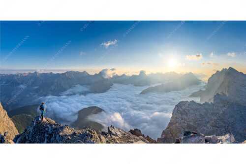 Bergsteiger blickt von der Kaskarspitze in den Sonnenaufgang im Karwendelgebirge - Felsenfest - Seitenverhältnis 2:1 - Kaskarspitze im Karwendel - weitere Infos unter https://www.kriner-weiermann.de