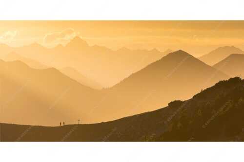 Zwei Wanderer genießen die Abendstimmung mit Blick hinüber zu den Allgäuer Alpen - Kraftort - Seitenverhältnis 2:1 - Abendstimmung im Estergebirge - weitere Infos unter https://www.kriner-weiermann.de