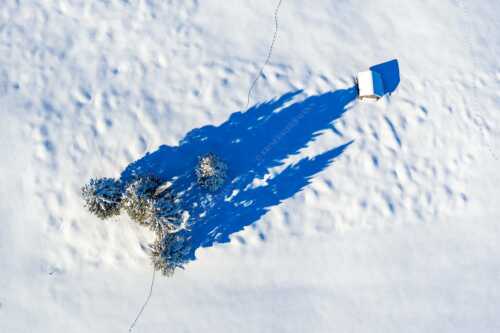 Blick auf eine Baumgruppe und Heustadel in Krün von Oben - Perspektive - Seitenverhältnis 3:2 - Lange Schatten im Schnee - weitere Infos unter https://www.kriner-weiermann.de