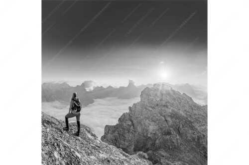 Blick von der Kaskarspitze im Karwendel über Nebelmeer in den Sonnenaufgang - Versteinert - Seitenverhältnis 1:1 - Bergsteigerin auf Kaskarspitze im Karwendel - weitere Infos unter https://www.kriner-weiermann.de