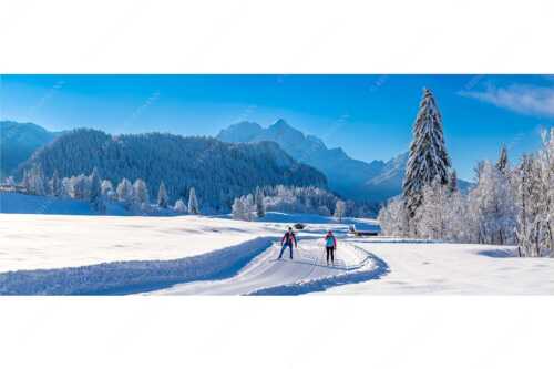 Zwei Langläufer genießen die perfekten Schneeverhältnisse im Elmauer Tal - Zwei Stile - ein Ziel - Seitenverhältnis 2,5:1 - Langlaufen in Elmau - weitere Infos unter https://www.kriner-weiermann.de