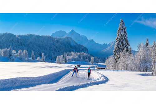 Zwei Langläufer genießen die perfekten Schneeverhältnisse im Elmauer Tal - Zwei Stile - ein Ziel - Seitenverhältnis 2:1 - Langlaufen in Elmau - weitere Infos unter https://www.kriner-weiermann.de