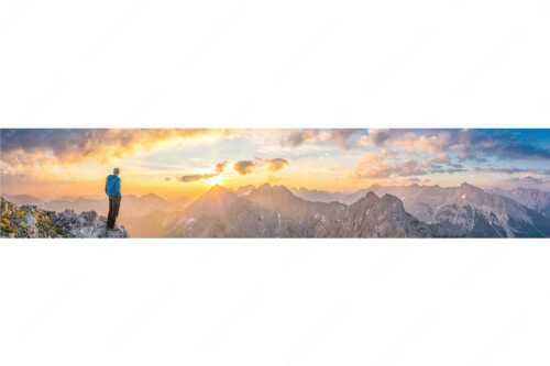 Bergsteiger genießt Sonnenaufgang über dem Wörner im Karwendel - Wieder ein neuer Tag - Seitenverhältnis 5:1 - Bergsteiger Sonnenaufgang Wörner - weitere Infos unter https://www.kriner-weiermann.de